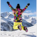 Girls' multi-color letter print puffer jacket model back view jump shot alpine snow mountain, full zip hooded, rib knit hem and cuffs