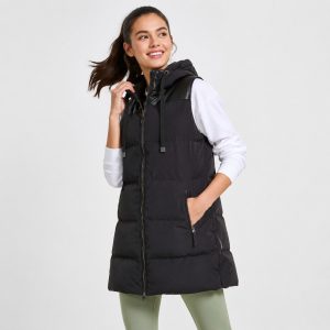 Women's black puffer vest model front view, full zip, hood with leather trim, drawcord, side zip pockets, long length