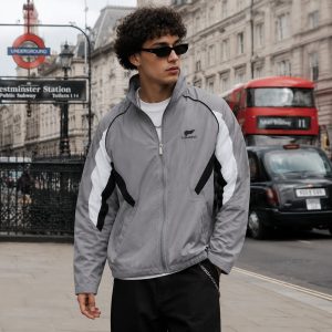 Men's windbreaker in grey with white panels and black piping, model front view London Westminster urban lifestyle, full zip, stand collar, side pockets