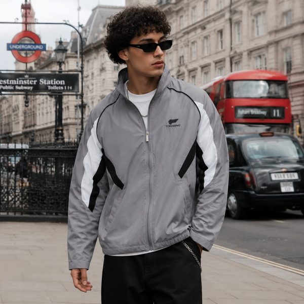 Men's windbreaker in grey with white panels and black piping, model front view London Westminster urban lifestyle, full zip, stand collar, side pockets