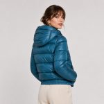 Women's cropped lightweight puffer jacket in petrol blue with hood, twin zip hand pockets, elasticated ribbed cuffs and hem - model back view, OEM wholesale women's outerwear