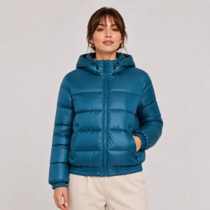 Women's cropped lightweight puffer jacket in petrol blue with hood, twin zip hand pockets, elasticated ribbed cuffs and hem - model front view, OEM wholesale women's outerwear