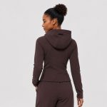 Women's athletic zip-hoodie jacket in chocolate brown with princess seams and thumbhole cuffs - model back view, OEM wholesale women's activewear, sizes XS-XL
