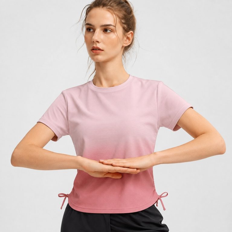 Women's athletic workout top in black ombre gradient (dark grey at neck fading to black at hem) with side drawstring ruching - model back view, OEM wholesale women's activewear, sizes XS-XL