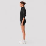 Women's black high-waisted biker workout shorts, side full body view, white sneakers