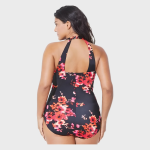 Rear view of a model wearing a black one-piece swimsuit with a vibrant red and orange floral print, featuring a halter neck and open back, against a neutral background.