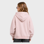 Back view of a child model wearing a pastel pink hooded sweatshirt with dropped shoulders, ribbed hem, and relaxed sleeves, styled with grey denim jeans in a studio setting.
