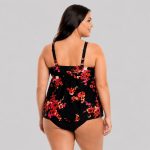 Women's plus-size black tankini top with red, orange, pink, and yellow floral print, scoop neck, dual adjustable wide straps, straight back, empire waist ruffle hem, matching black brief, model back view