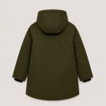 Boy's olive green mid-length utility parka puffer jacket back view, hood with drawstring and black inner lining visible, horizontal back yoke seam, mid-length thigh-length silhouette, no text or logo on back, kid model back view with black knit beanie, cream turtleneck, black cargo pants, clean light gray studio background