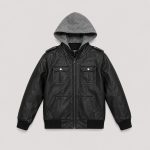 Boy's black faux leather (PU leather) bomber jacket flat lay product photo back, heather gray hooded sweatshirt hood visible folded inside collar, epaulettes on each shoulder with silver snap button, ribbed cuffs and hem, no text or logo, clean white studio background for B2B catalog