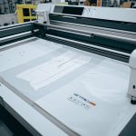 Automated fabric cutting machinery in a modern garment factory, computer-controlled cutting system.
