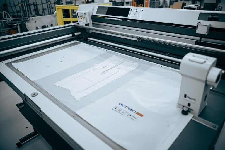 Automated fabric cutting machinery in a modern garment factory, computer-controlled cutting system.