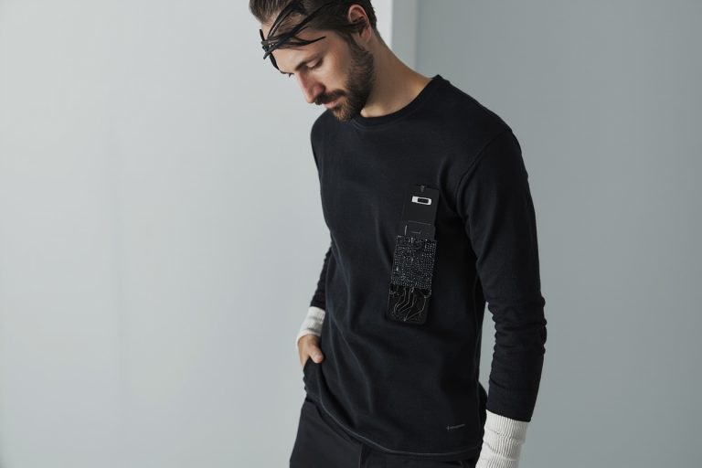 Smart garment with embedded electronic sensor strip and conductive thread, minimalist product photography.