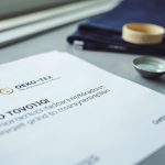 OEKO-TEX Standard 100 textile certification document on a desk with fabric swatches