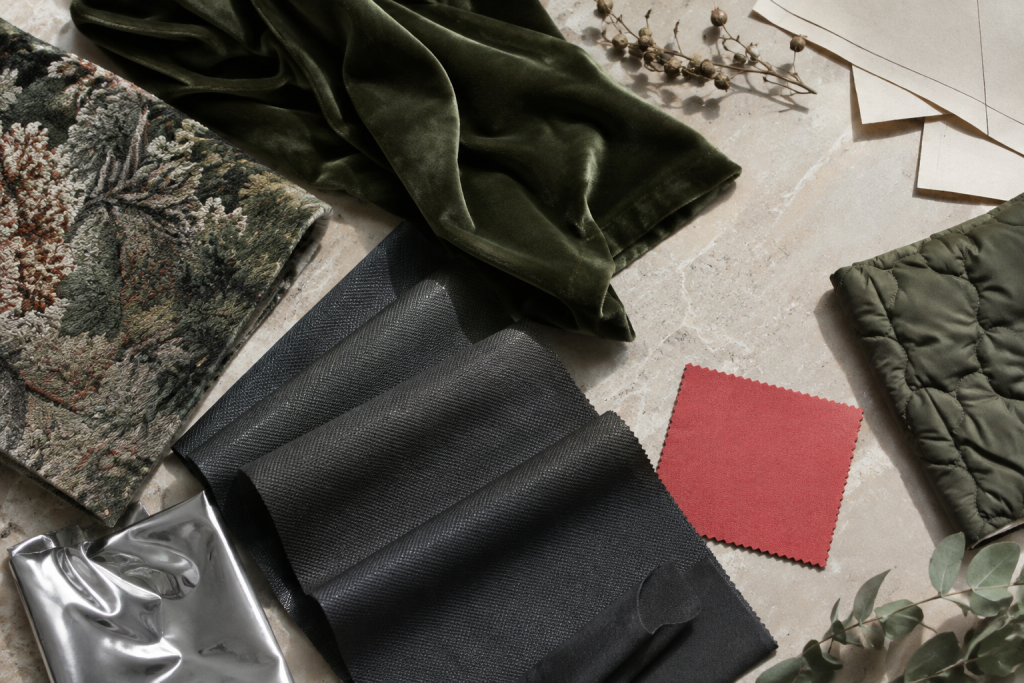 AI-generated still life of green velvet, botanical jacquard, charcoal fabric and reflective textile swatches