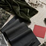 AI-generated still life of green velvet, botanical jacquard, charcoal fabric and reflective textile swatches