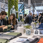 Chinese textile suppliers and international apparel buyers examining performance fabrics at a Shanghai trade fair